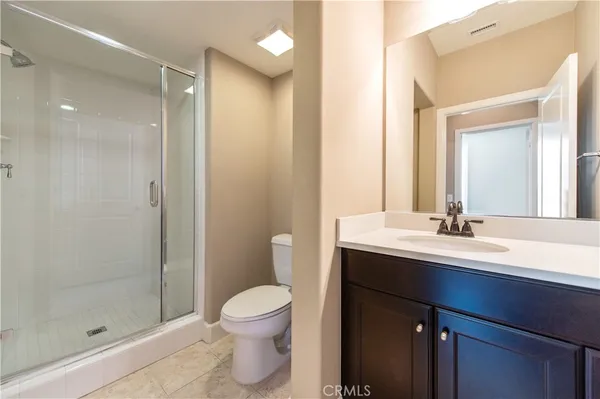 a bathroom with a sink a toilet a mirror and shower