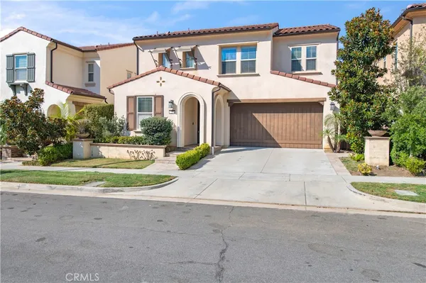 a view of white house with a yard and potted plants