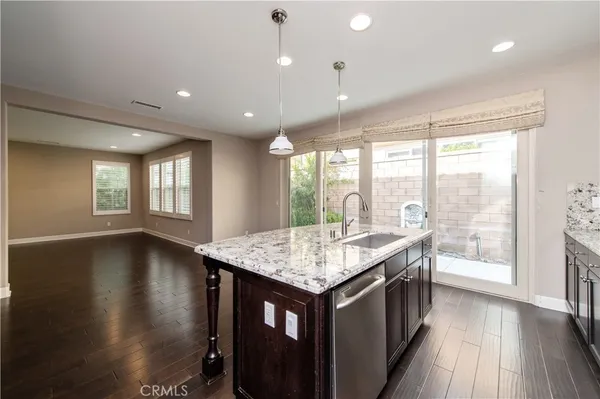a kitchen with a counter space wooden floor and a floor to ceiling window