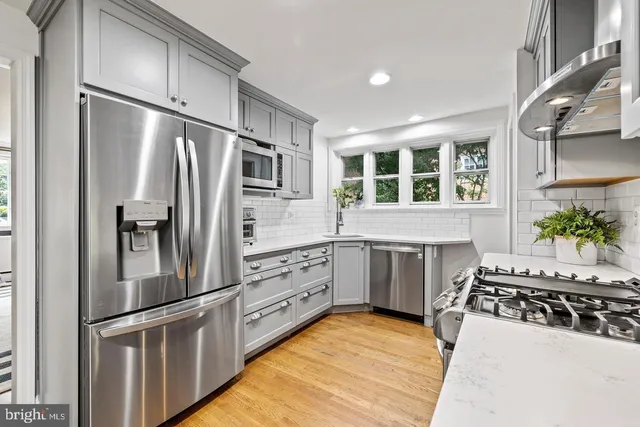 a kitchen with stainless steel appliances a refrigerator sink and cabinets