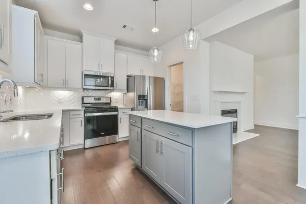 a kitchen with kitchen island a sink stainless steel appliances and cabinets
