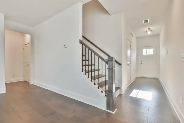 a view of a hallway with entryway with wooden floor