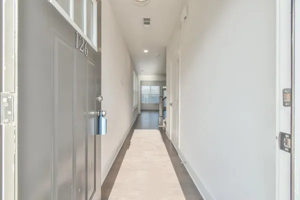 a view of a hallway with wooden floor and staircase