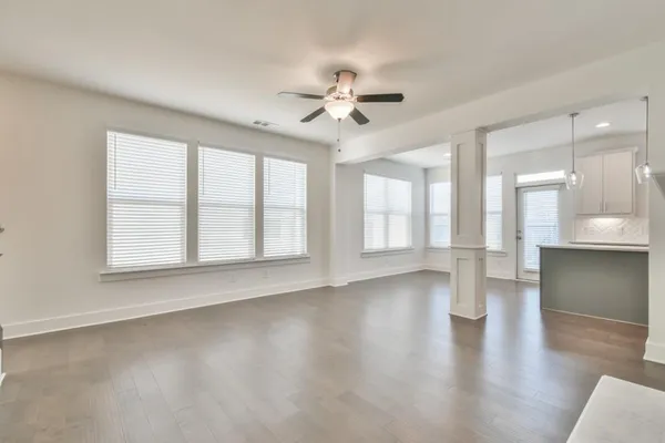 a view of an empty room with a window and wooden floor