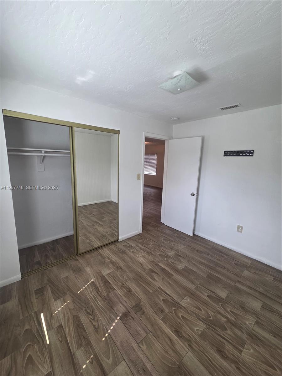 503 North 25th Street, Unit 2 Fort Pierce, FL 34947 - Photo 11 of 19 a view of an empty room with wooden floor and closet