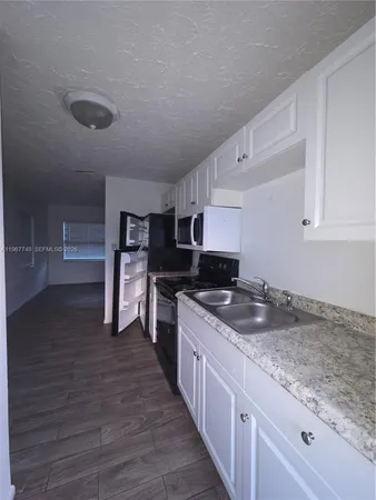 a kitchen with granite countertop a sink and counter top space