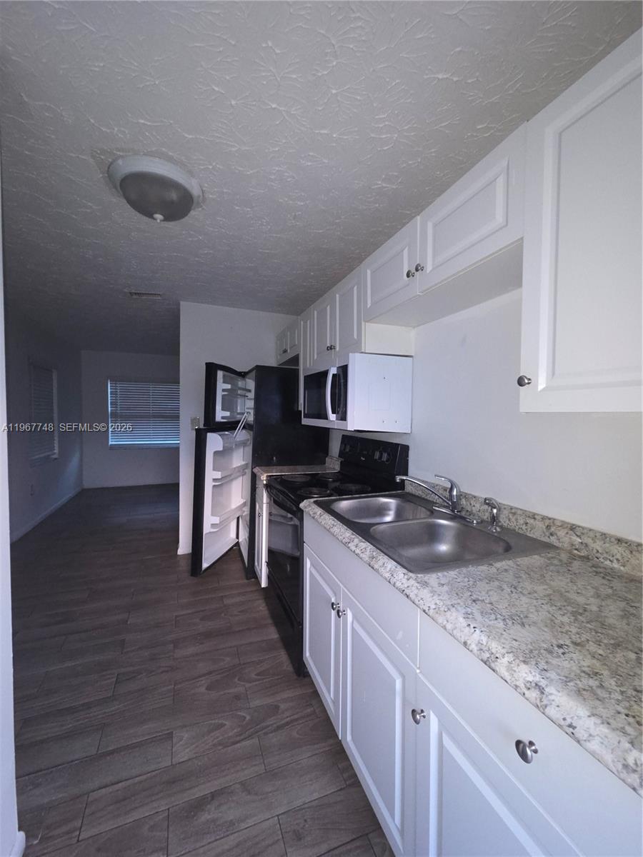 503 North 25th Street, Unit 2 Fort Pierce, FL 34947 - Photo 2 of 19 a kitchen with granite countertop a sink and counter top space
