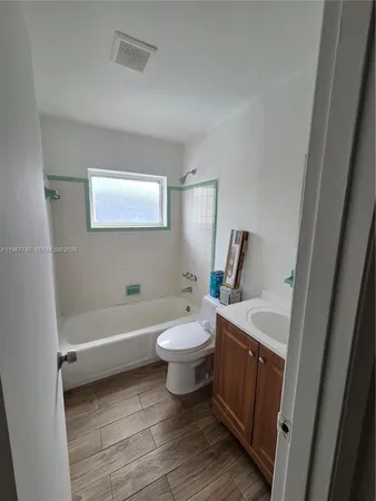 a bathroom with a double vanity sink toilet mirror and bathtub