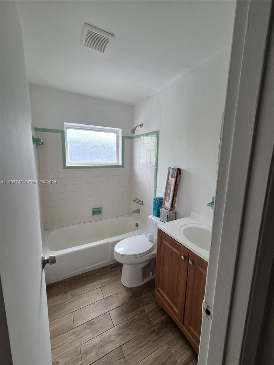 503 North 25th Street, Unit 2 Fort Pierce, FL 34947 - Photo 5 of 19 a bathroom with a double vanity sink toilet mirror and bathtub