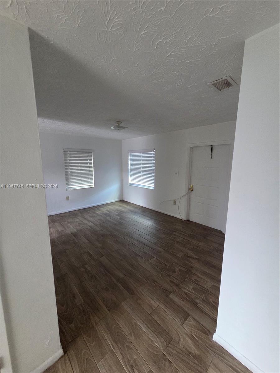 503 North 25th Street, Unit 2 Fort Pierce, FL 34947 - Photo 6 of 19 an empty room with wooden floor and windows