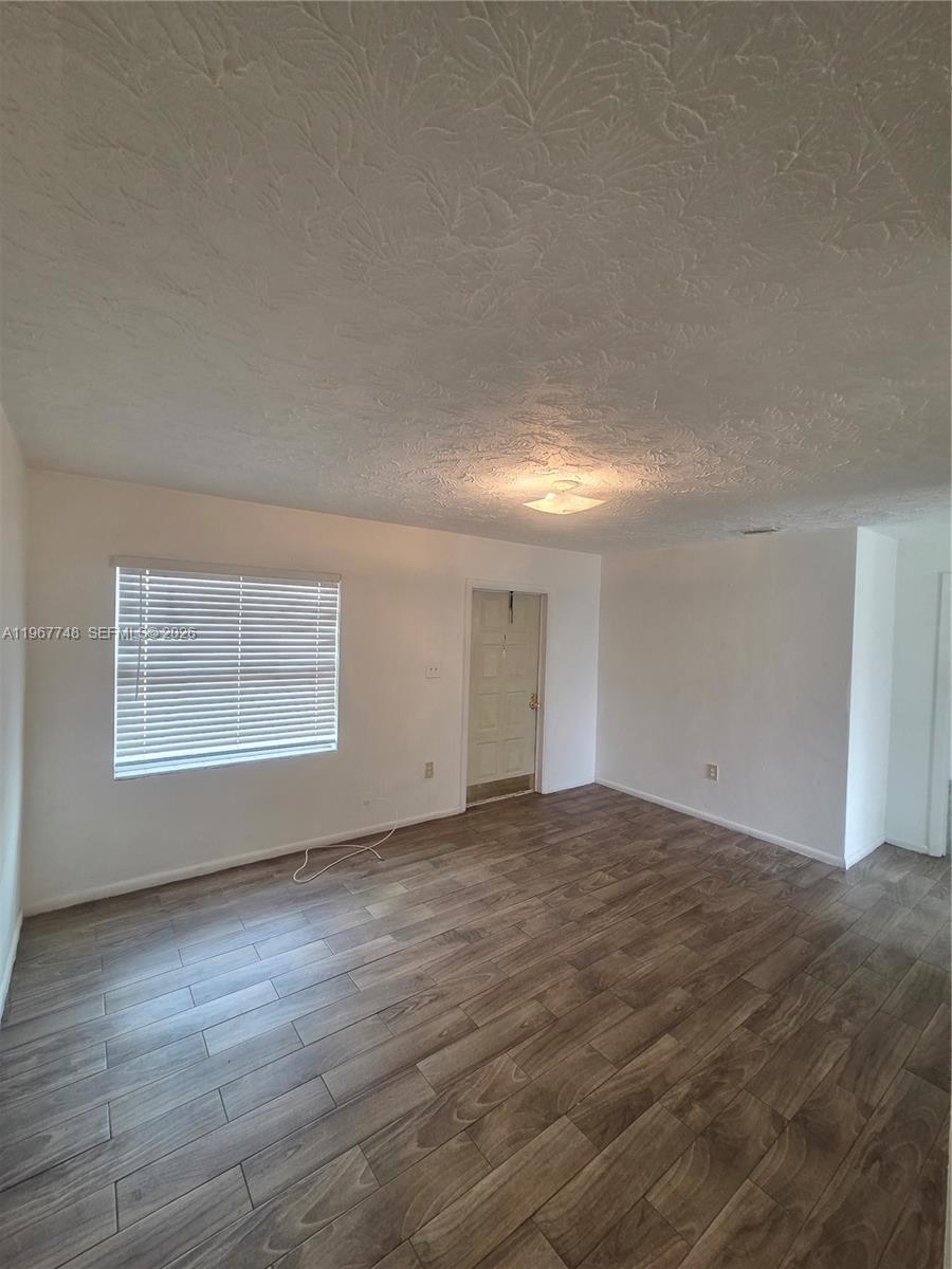 503 North 25th Street, Unit 2 Fort Pierce, FL 34947 - Photo 8 of 19 a view of an empty room with wooden floor and a window