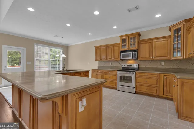 a large kitchen with stainless steel appliances granite countertop a sink and cabinets
