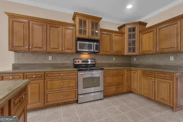 a kitchen with kitchen island granite countertop a sink a counter top stainless steel appliances and cabinets