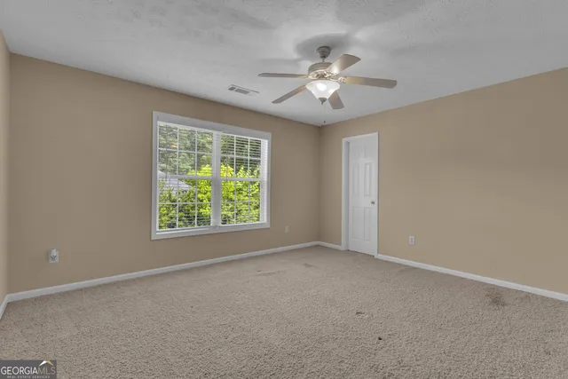 a view of a house with a big yard potted plants and large trees