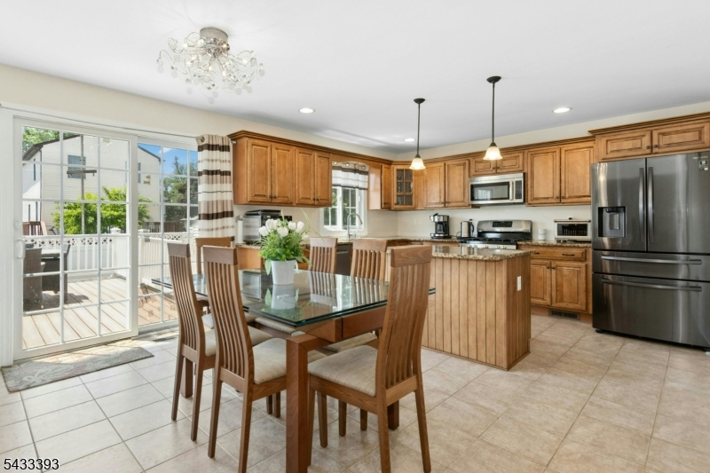 33 Stanton Street Clark, NJ 07066 - Photo 10 of 37 a kitchen with stainless steel appliances granite countertop a stove a refrigerator a oven a sink with a dining table and chairs