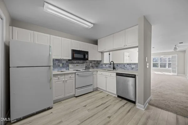a kitchen with white cabinets and white appliances