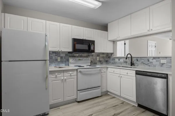 a kitchen with cabinets stainless steel appliances and a sink