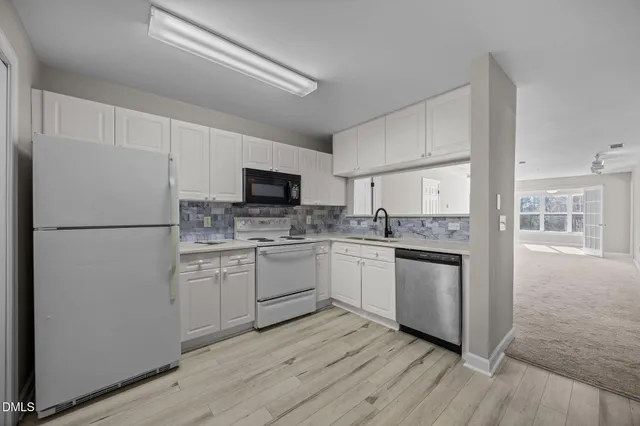 a kitchen with cabinets stainless steel appliances and a sink