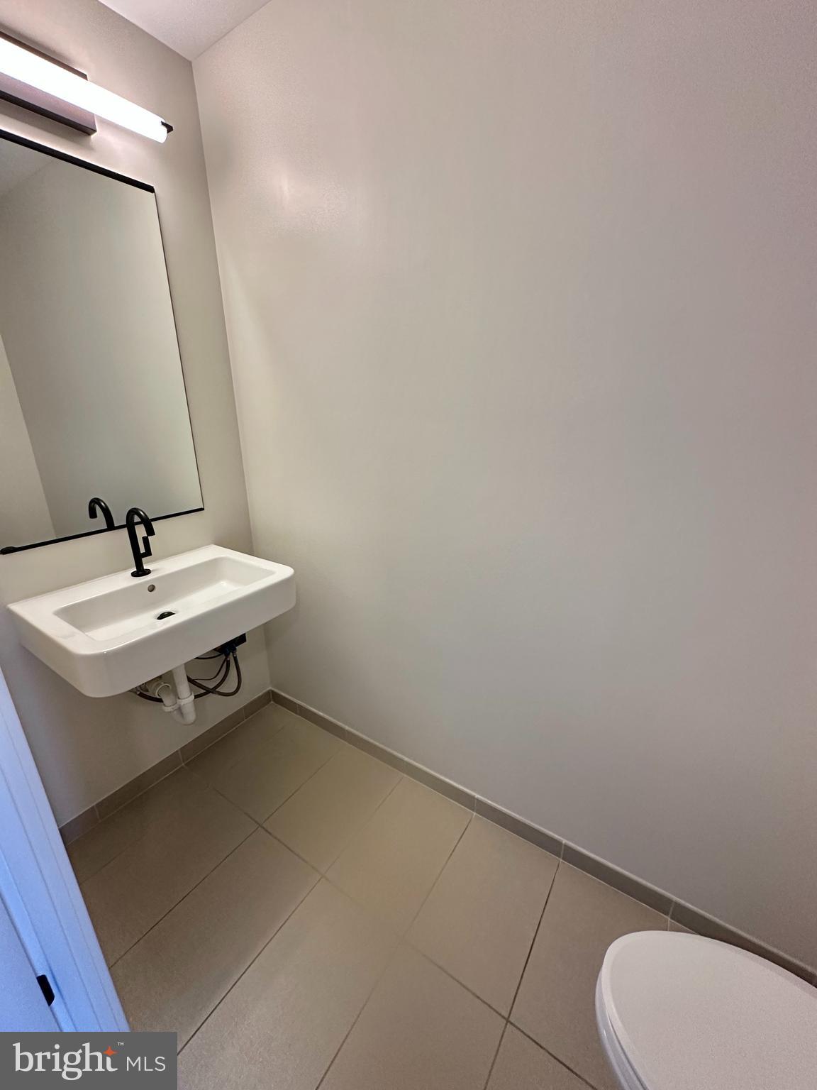 1211 Van Street Southeast, Unit 1201 Washington, DC 20003 - Photo 14 of 58 a bathroom with a sink toilet and mirror