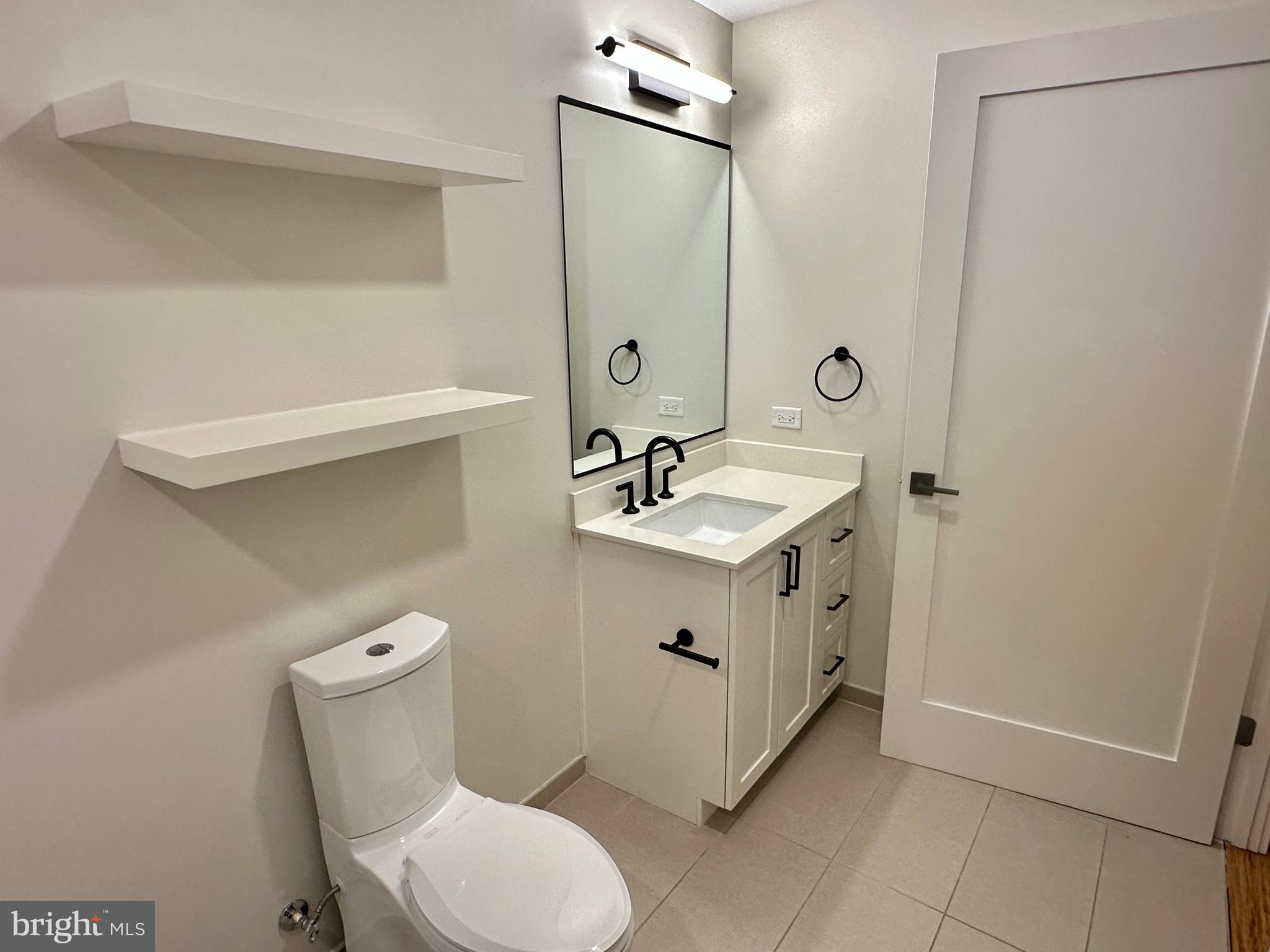 1211 Van Street Southeast, Unit 1201 Washington, DC 20003 - Photo 36 of 58 a spacious bathroom with a double vanity sink a toilet and a mirror