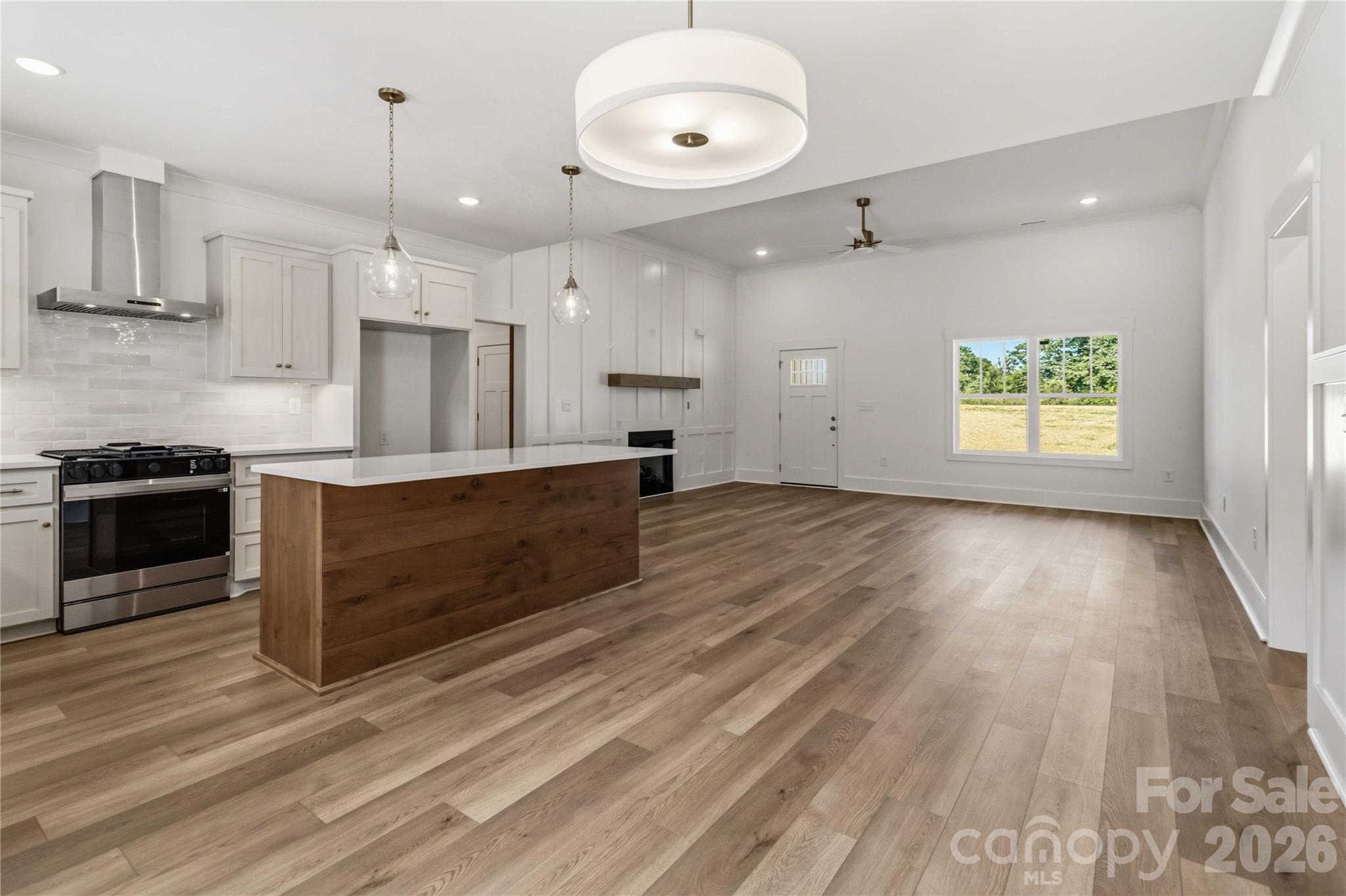 352 Adams Road Clover, SC 29710 - Photo 11 of 38 a large kitchen with stainless steel appliances kitchen island granite countertop a stove a sink and white cabinets with wooden floor