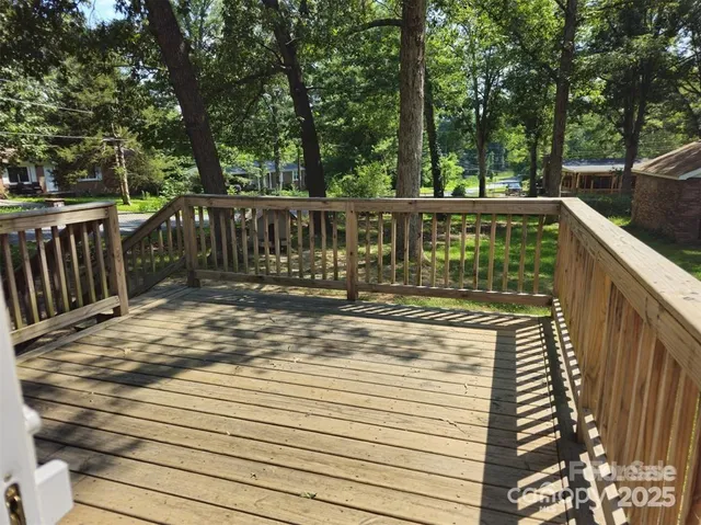 a view of deck with trees and wooden fence