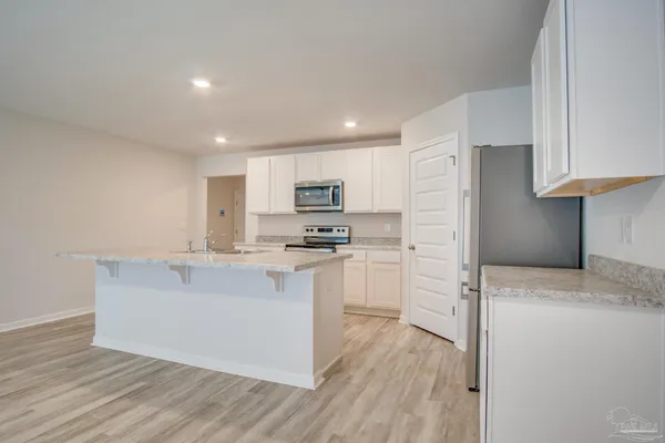 a kitchen with white cabinets and stainless steel appliances