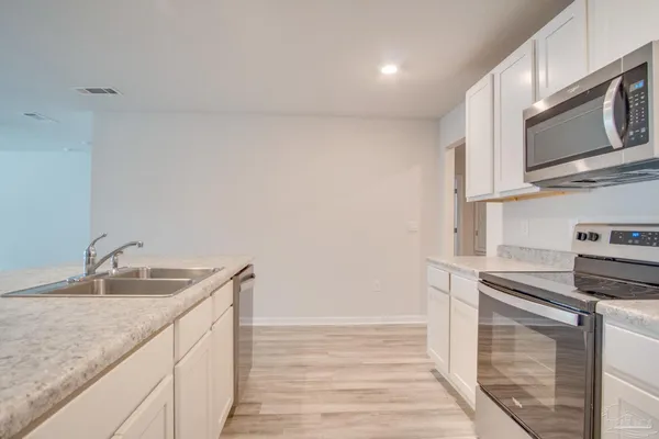 a kitchen with a sink microwave and cabinets