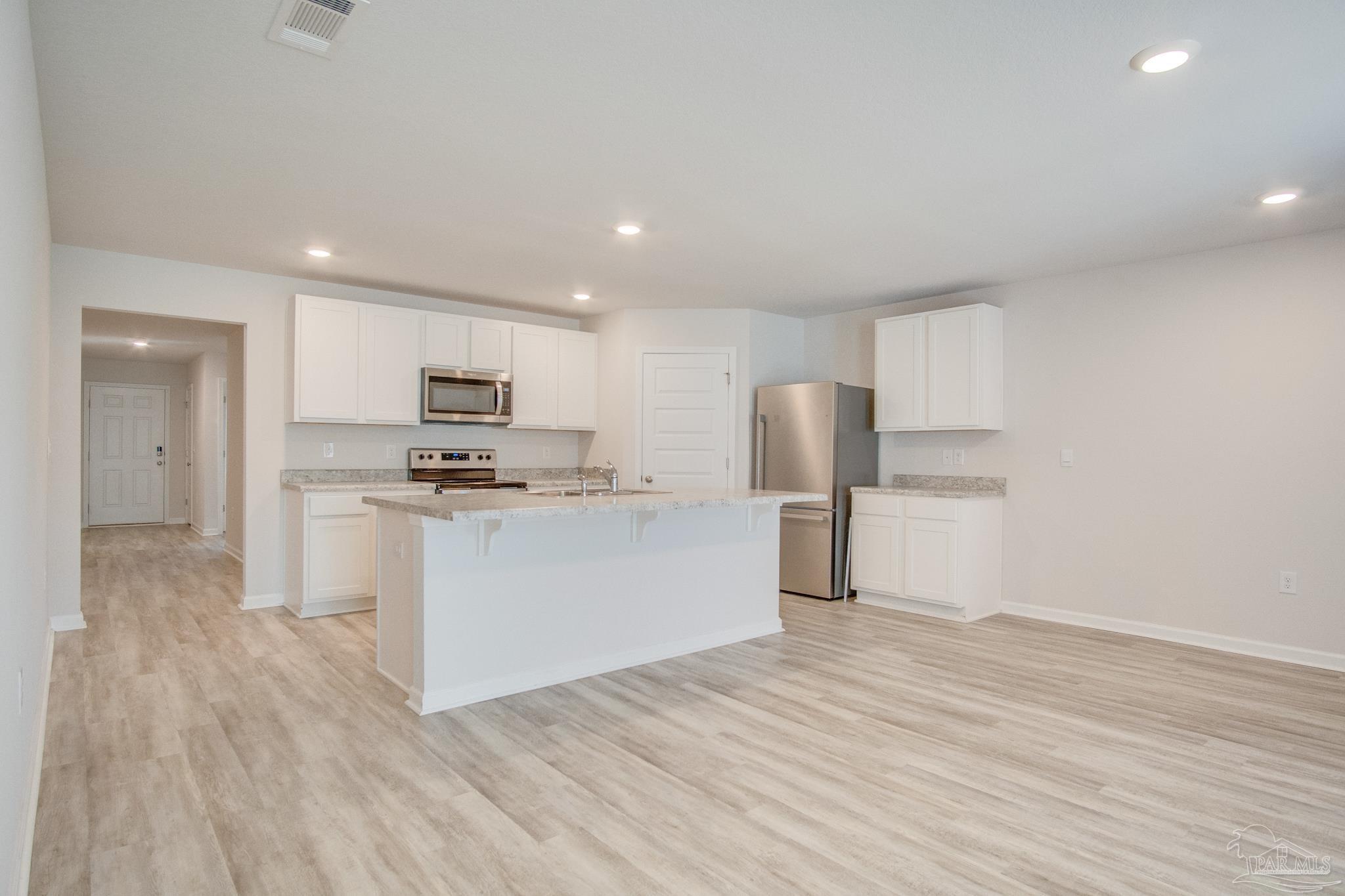 4383 White Cedar Court Pace, FL 32571 - Photo 13 of 36 a kitchen with white cabinets and stainless steel appliances