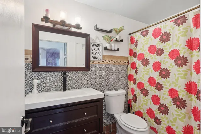 a bathroom with a sink mirror vanity and toilet