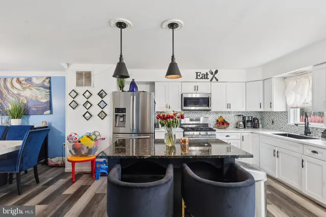 a kitchen with stainless steel appliances kitchen island granite countertop a sink and a stove
