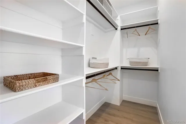 a view of walk in closet with wooden floor