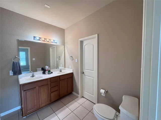 a spacious bathroom with a toilet sink and mirror