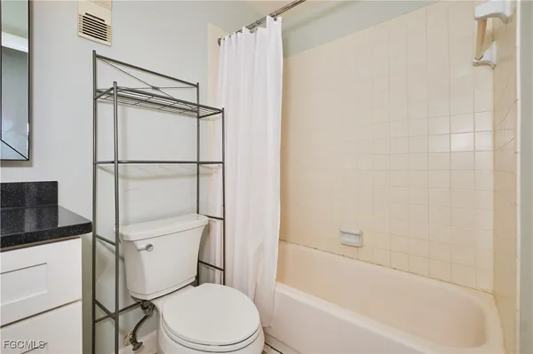 a white toilet sitting next to a bath tub