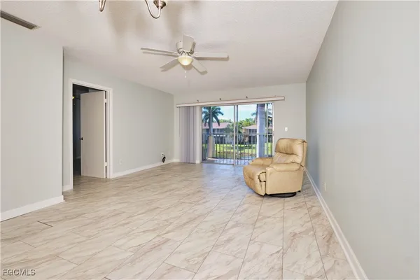 a living room with furniture and a floor to ceiling window