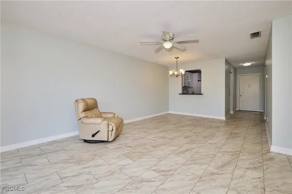 a view of empty room with cabinet and ceiling fan