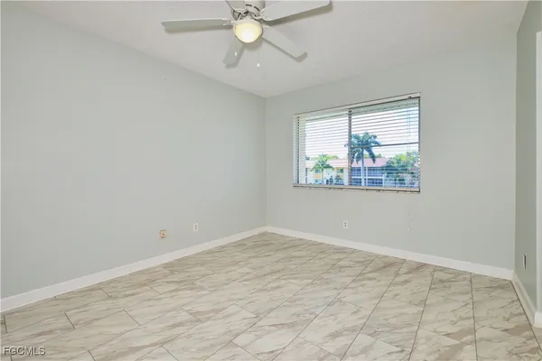 an empty room with fan and window