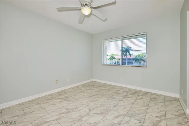 an empty room with fan and window