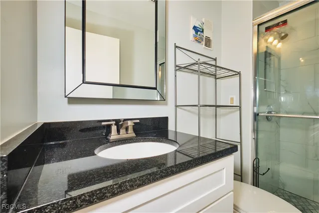 a bathroom with a granite countertop sink and a mirror