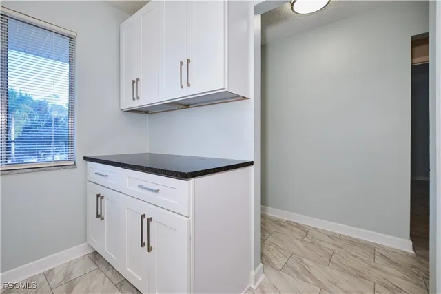 a kitchen with white cabinets and a white stove