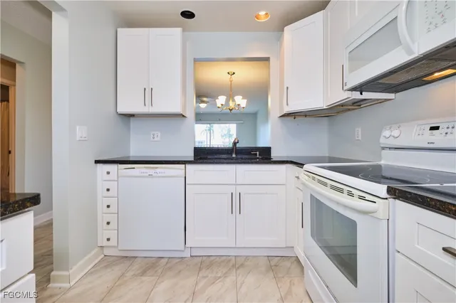 a kitchen with white cabinets and white appliances