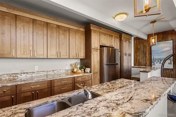 a kitchen with stainless steel appliances kitchen island granite countertop a refrigerator stove and sink
