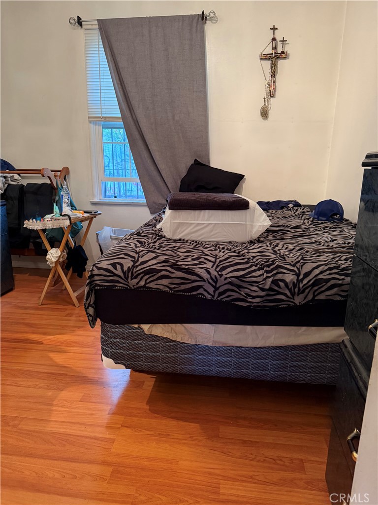 13116 Weidner Street Pacoima, CA 91331 - Photo 11 of 21 a bedroom with a bed and wooden floor