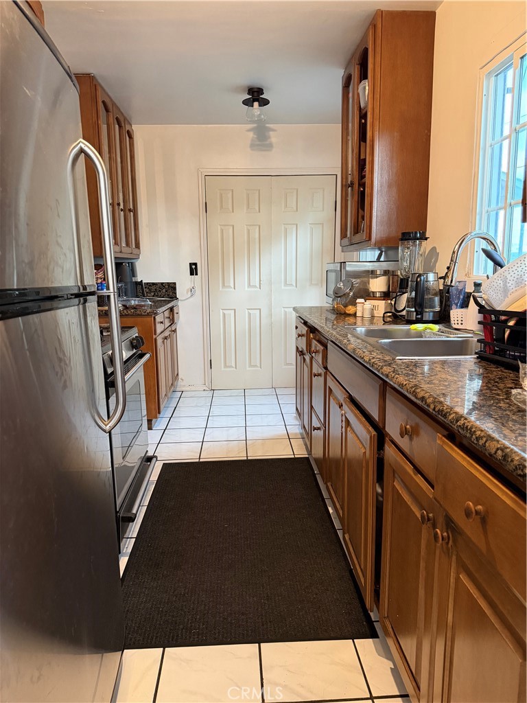 13116 Weidner Street Pacoima, CA 91331 - Photo 5 of 21 a kitchen with stainless steel appliances granite countertop a refrigerator a stove and a sink with wooden floor