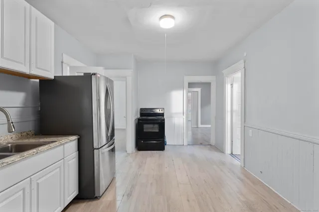 a kitchen with a refrigerator and a stove top oven