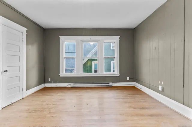an empty room with wooden floor and a window