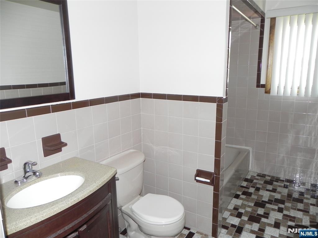 52 Wilson Street, Unit 2 Little Ferry, NJ 07643 - Photo 6 of 11 a bathroom with a sink a toilet a mirror and shower