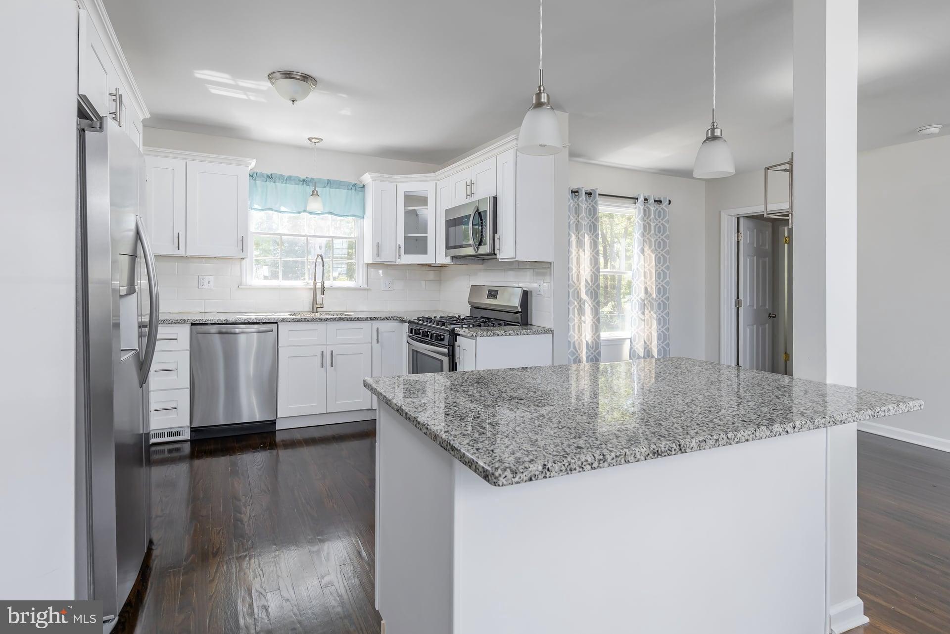 1203 Cedar Drive Pine Hill, NJ 08021 - Photo 6 of 19 a kitchen with stainless steel appliances granite countertop a sink refrigerator and cabinets