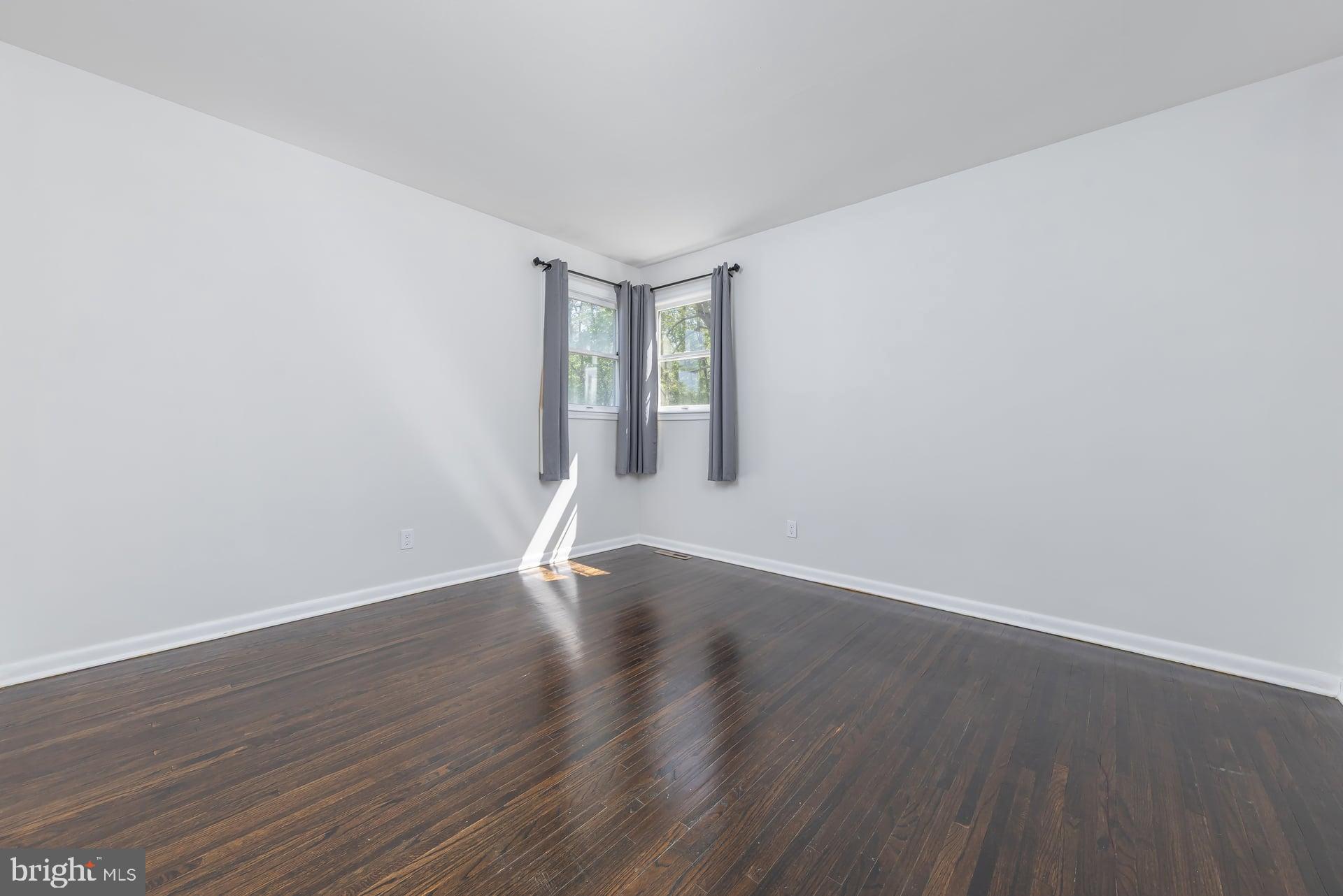 1203 Cedar Drive Pine Hill, NJ 08021 - Photo 10 of 19 an empty room with wooden floor and windows