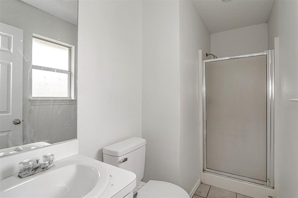 606 McAnear Street Cleburne, TX 76033 - Photo 12 of 19 a bathroom with a sink a toilet and shower